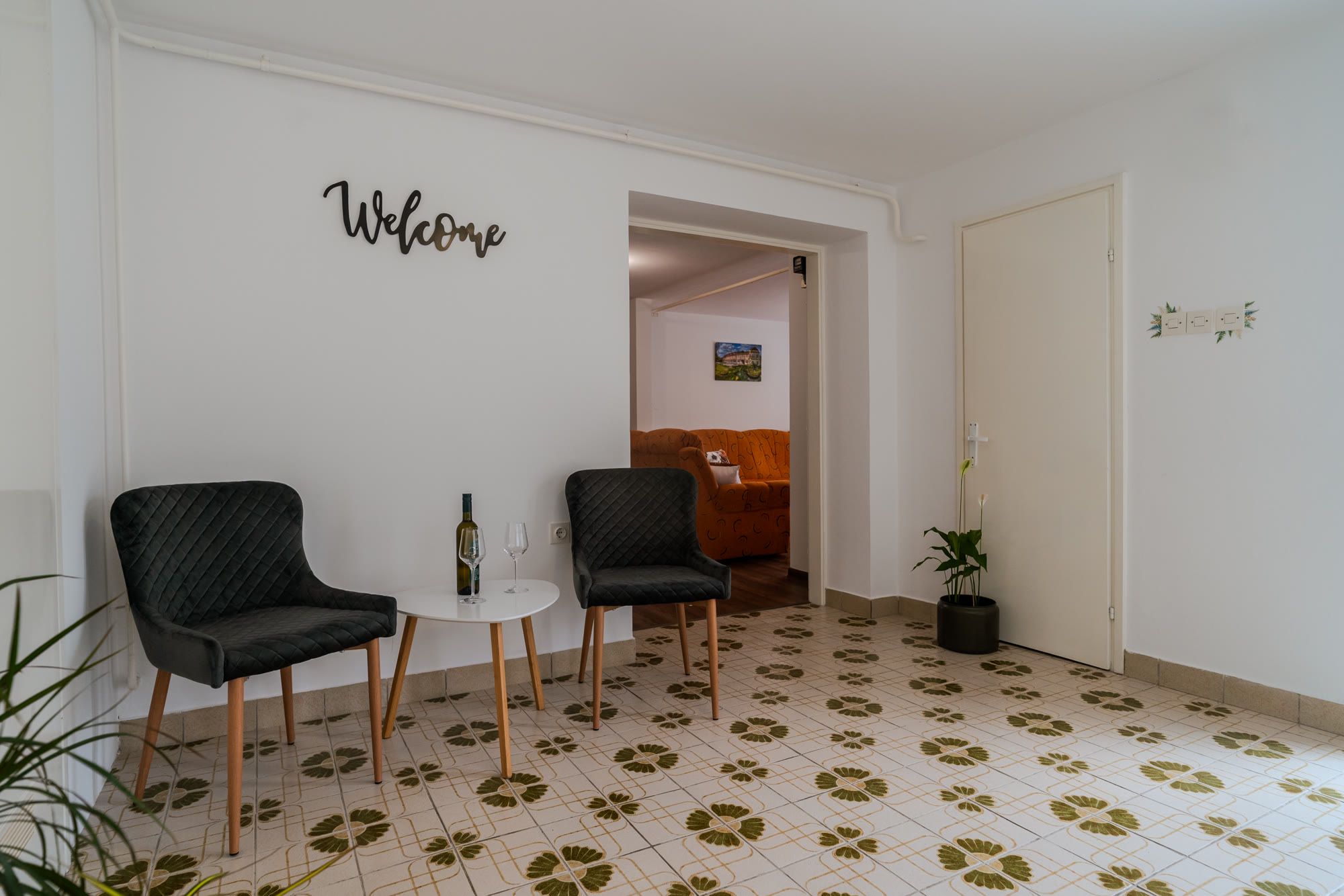 Predsoblje s natpisom Welcome, dvije fotelje i prolazom u dnevni boravak